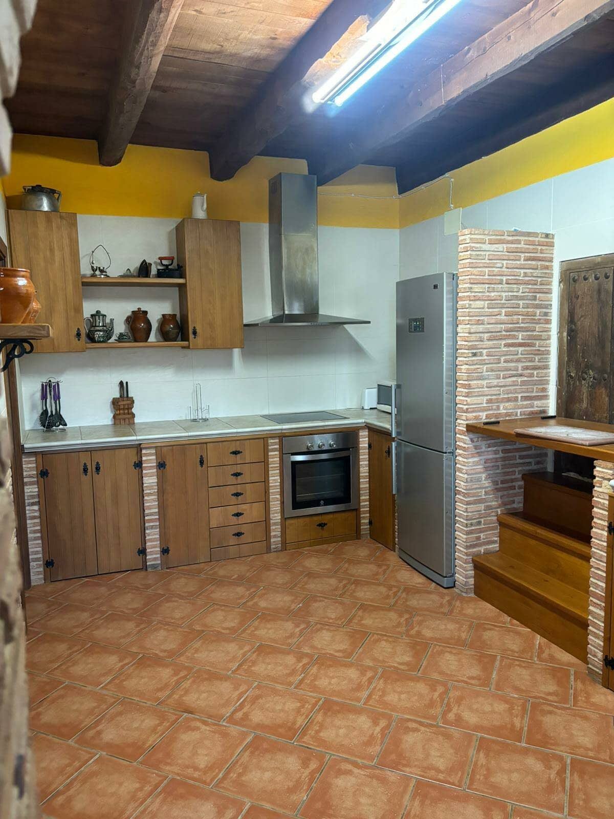 Una cocina con gabinetes de madera y un refrigerador de acero inoxidable.