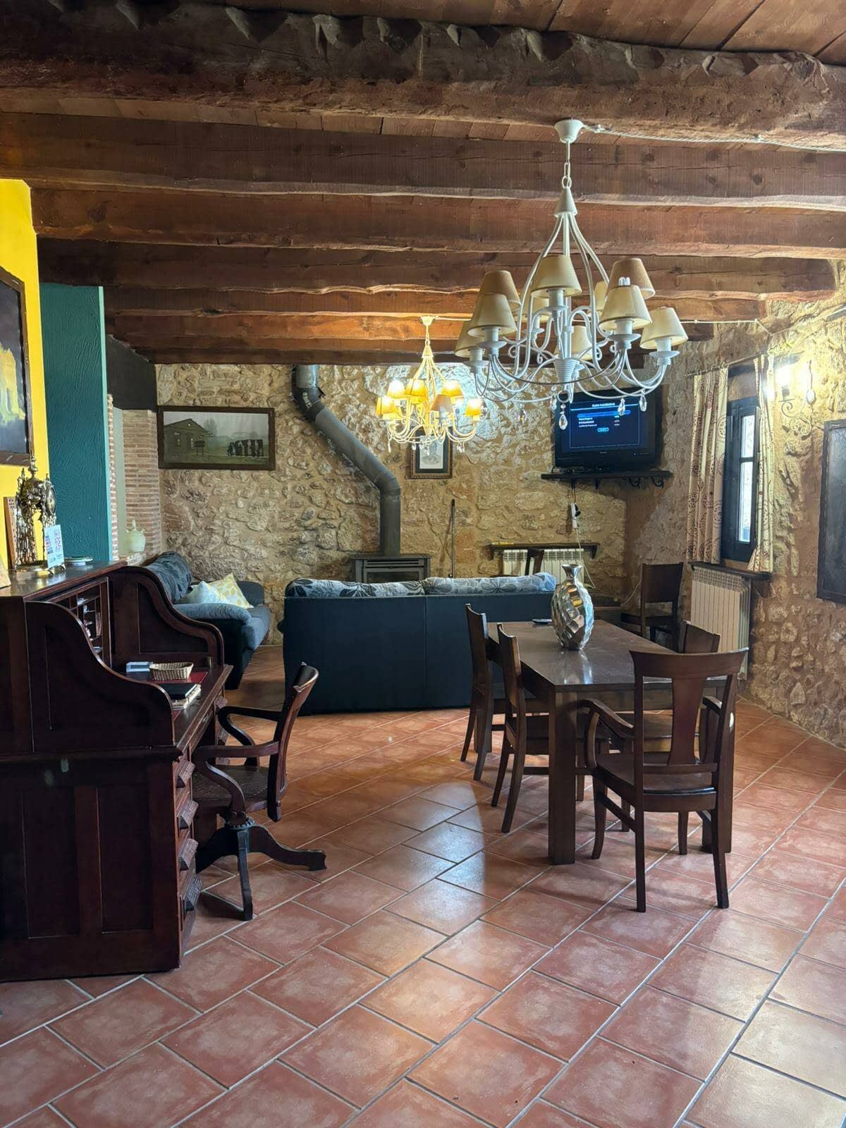 Una sala de estar con una mesa y sillas y un televisor.