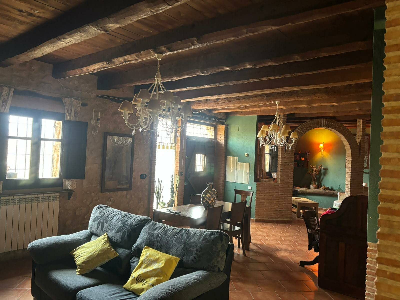 Una sala de estar con un sofá, una silla, una mesa y una lámpara de araña.