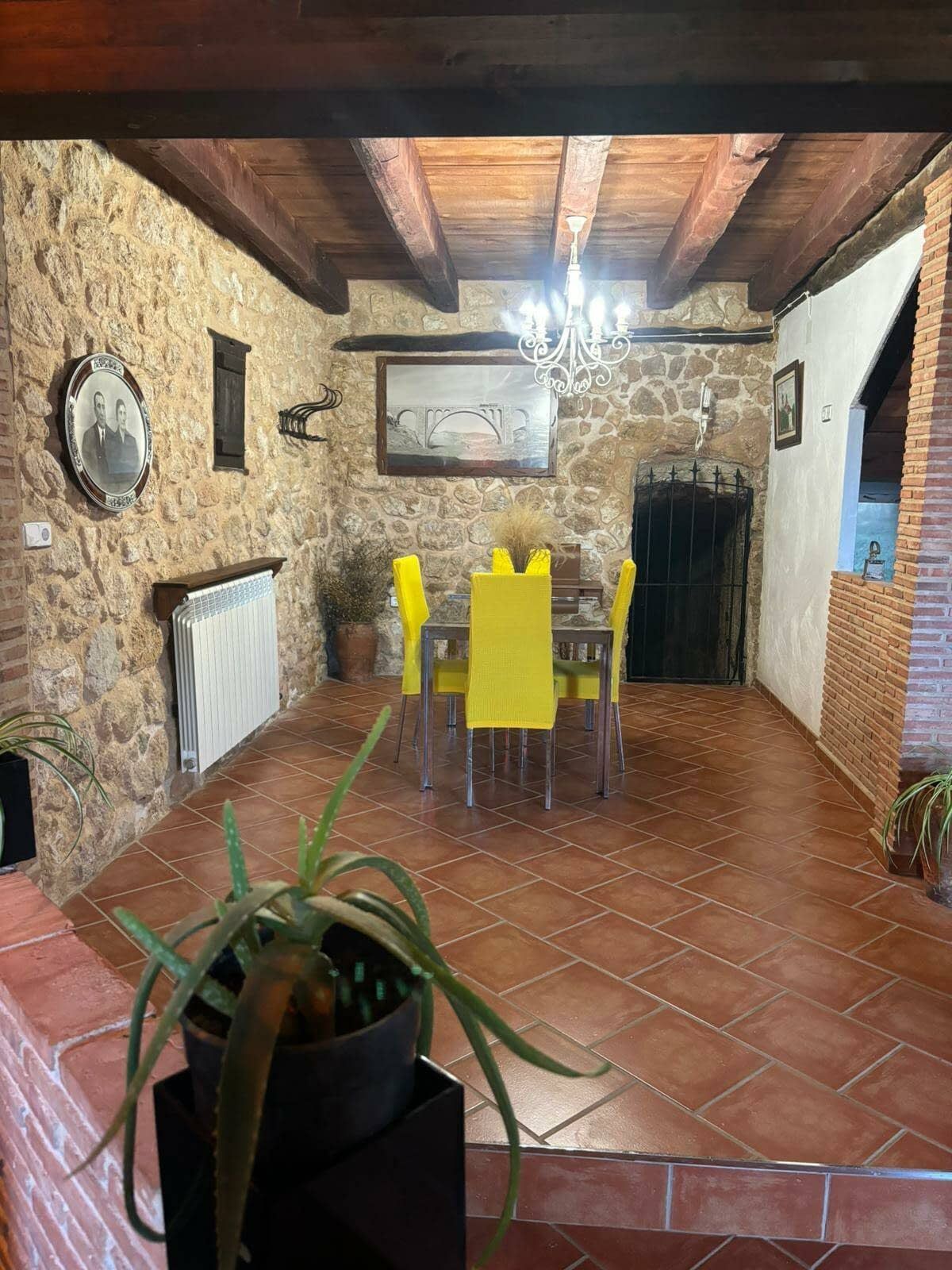 Un comedor con una mesa y sillas y una planta en maceta.