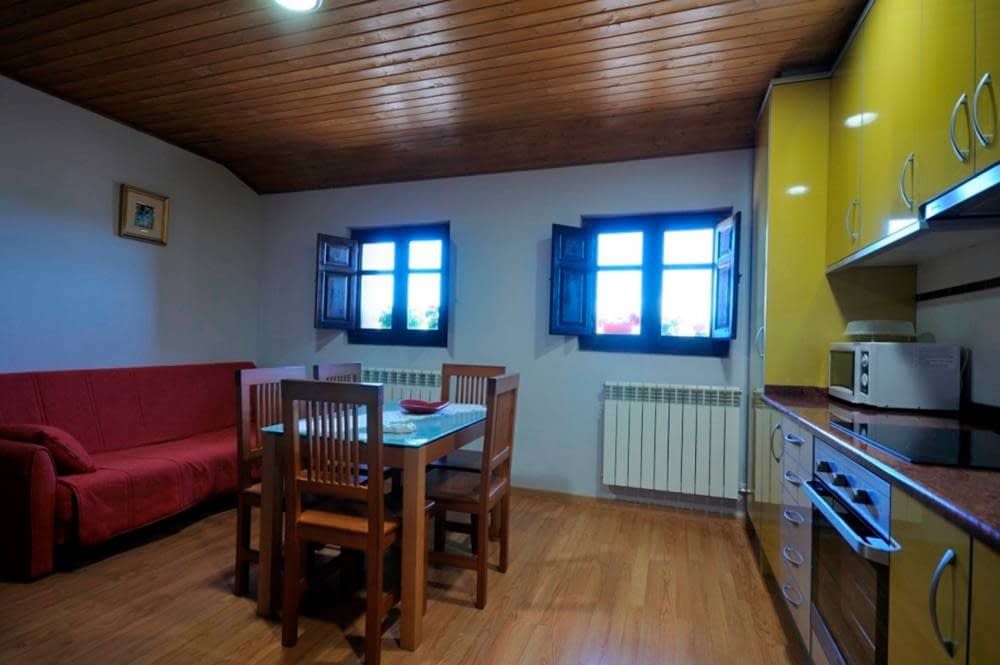 Una cocina con gabinetes amarillos y un sofá rojo.