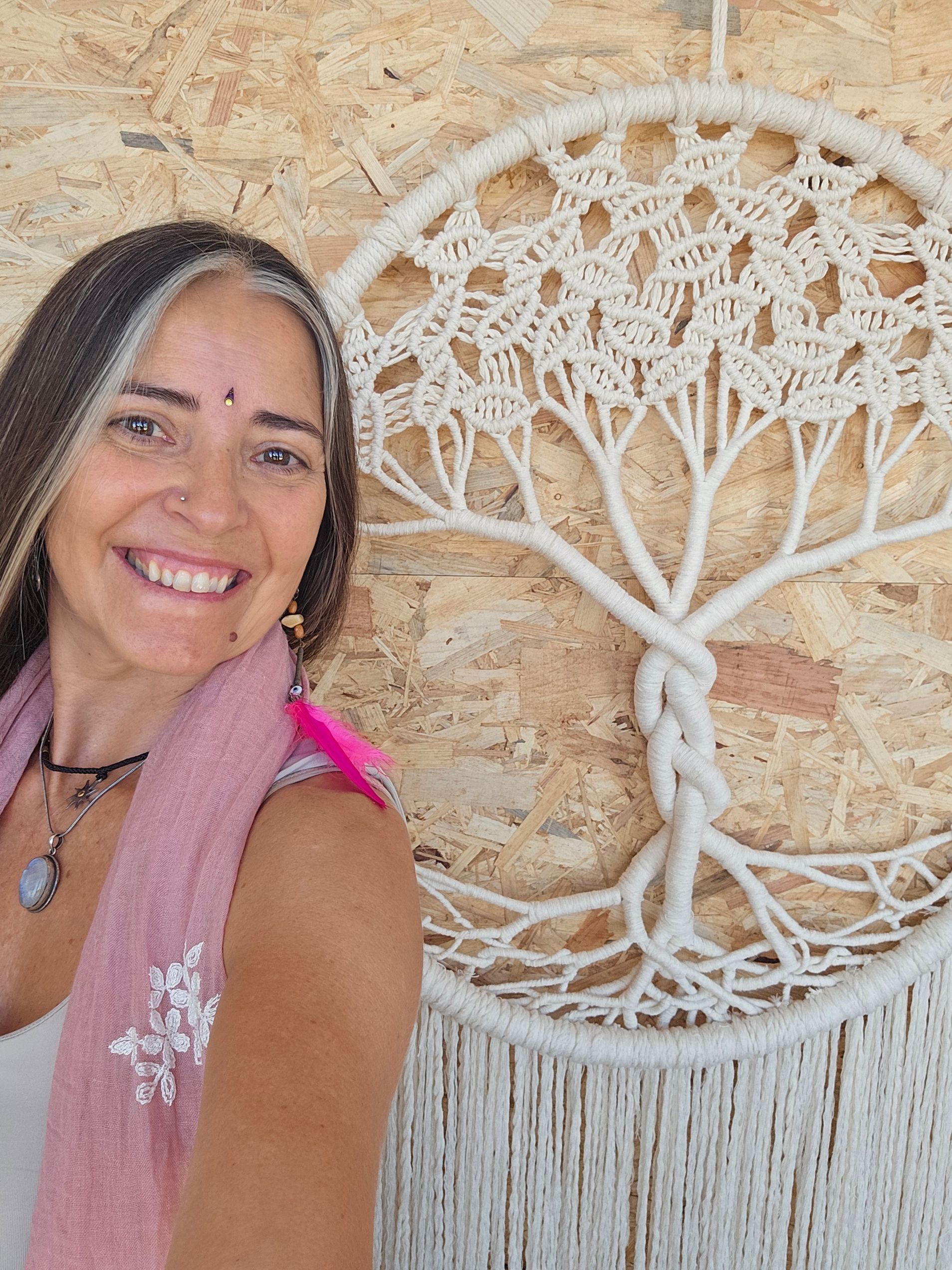 Una mujer está sentada en una habitación rodeada de cuencos y un gong.