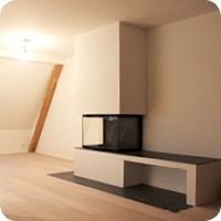 Modernes, minimalistisches Wohnzimmer mit eingebauter weisser Sitzbank und schwarzem Kamin vor einer beigen Wand