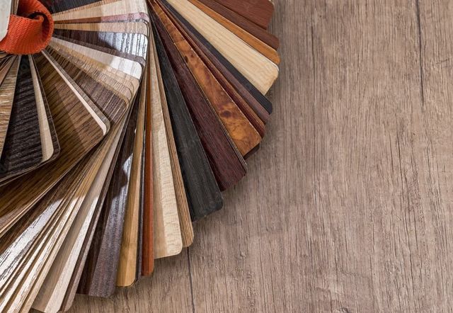 Fächer aus verschiedenen Holz- und Laminatbodenmustern auf einer holzstrukturierten Oberfläche