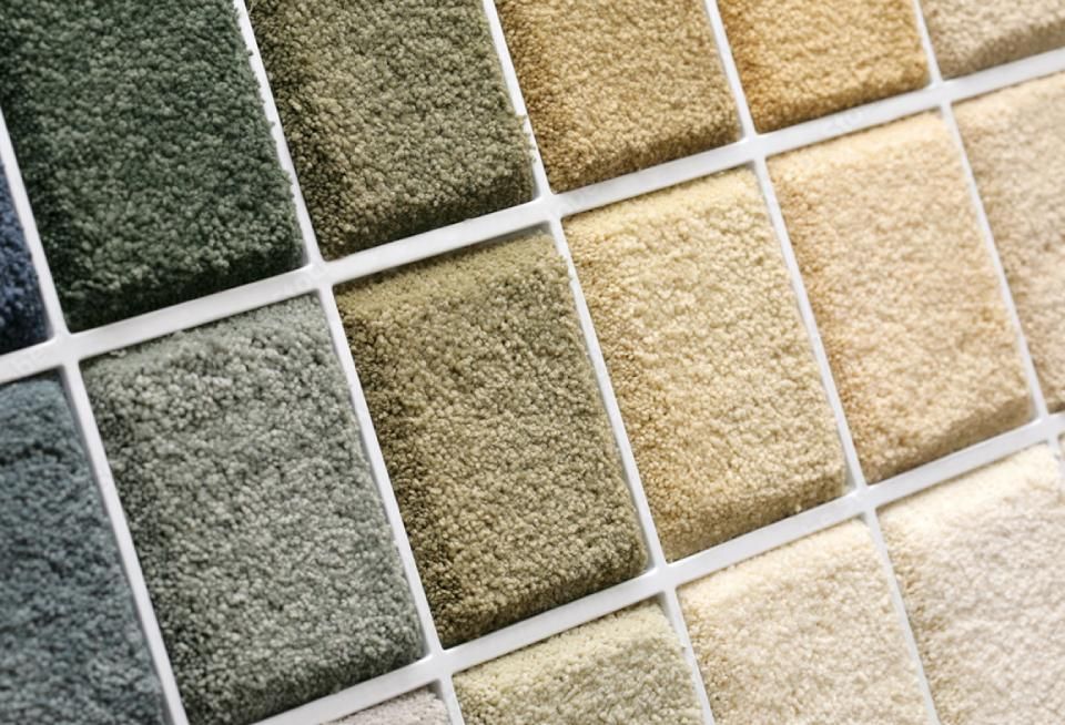 Musterteppiche in Grau, Grün, Beige und Creme, diagonal angeordnet.