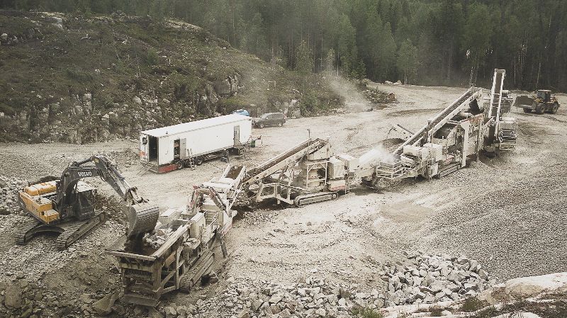 Romahtanut rakennustyömaa, vaurioituneet raskaat koneet ja valkoinen perävaunu mutaisella rinteellä