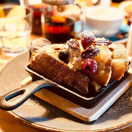 French toast with berries and pecans in a skillet on a plate