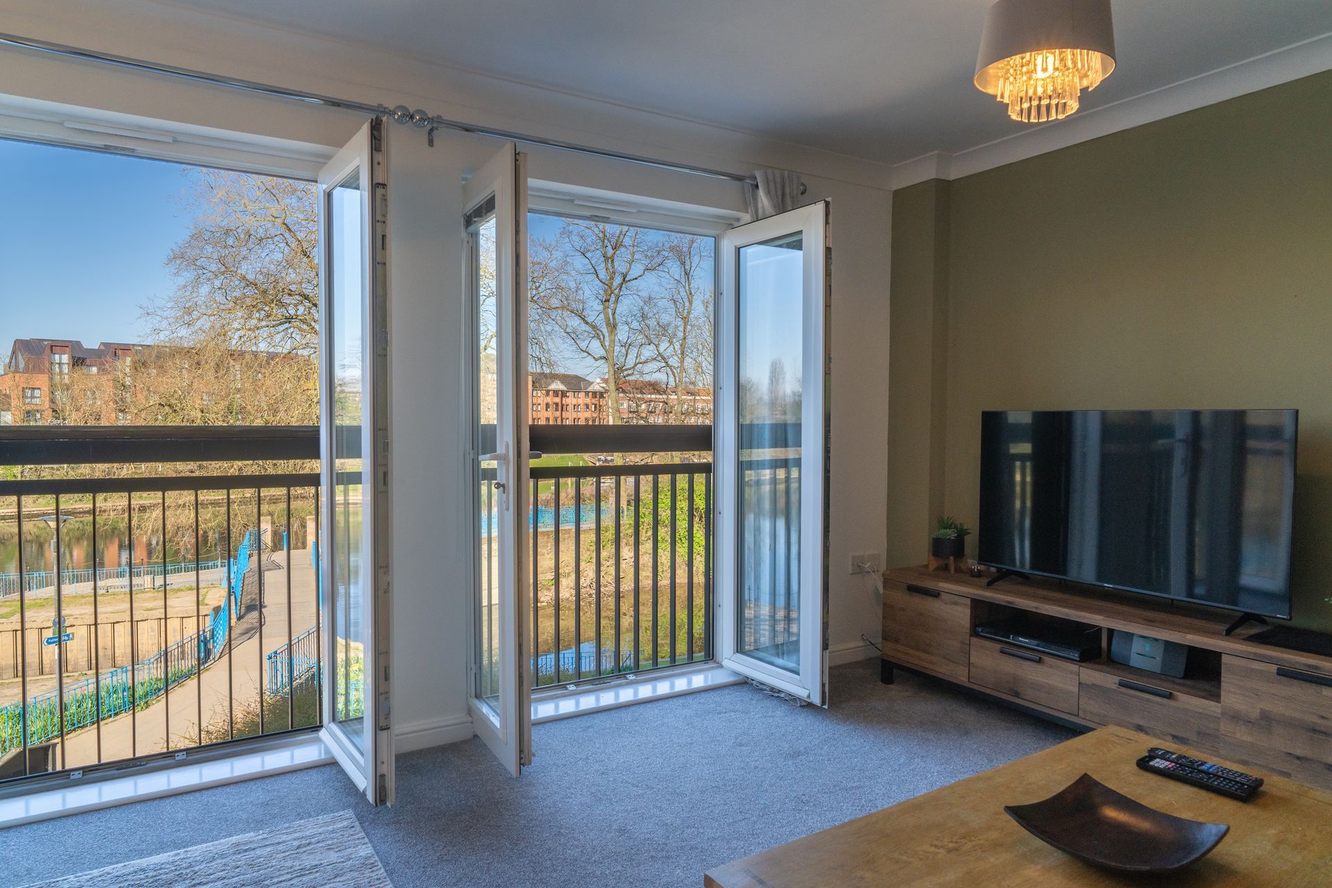 A living room with a flat screen tv and a balcony.
