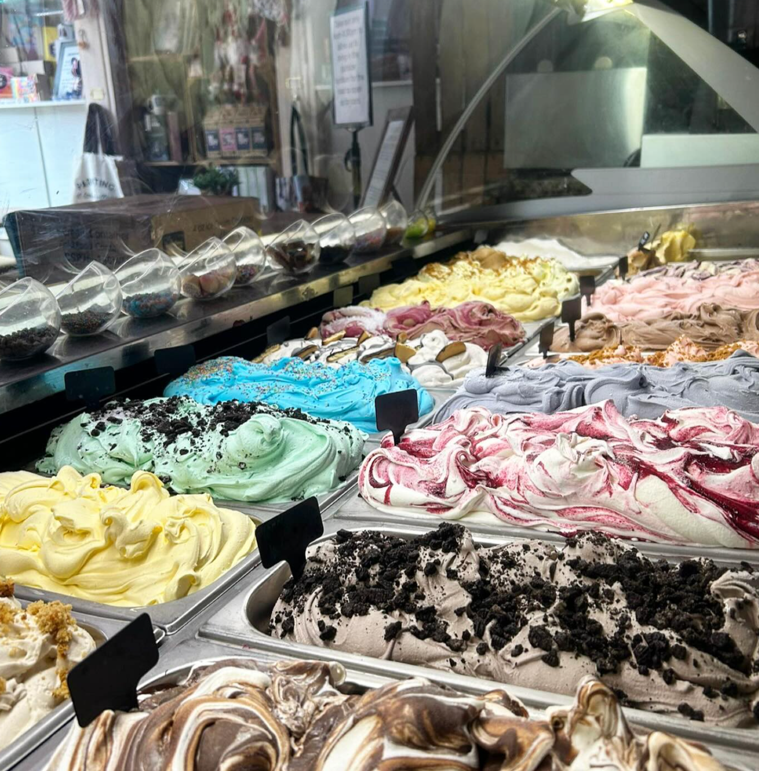 Gelato display case with various colorful flavors.