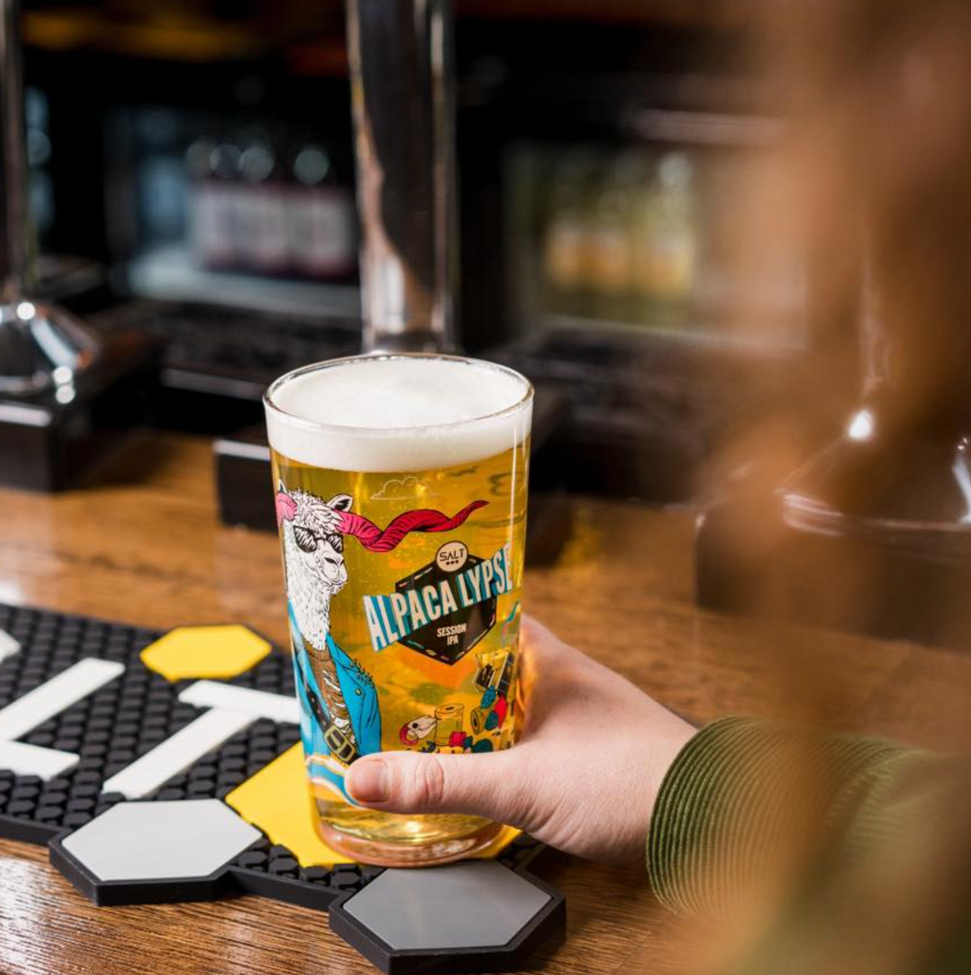 Person holding a glass of beer with 