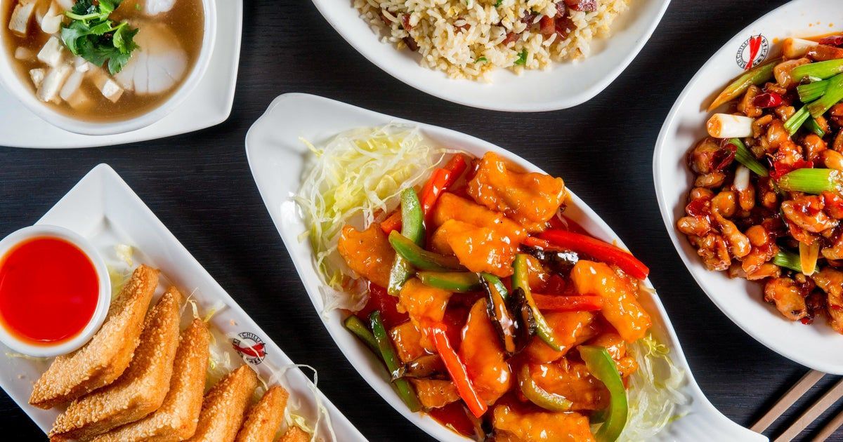 Assorted Chinese dishes on white plates: tofu, fried rice, soup, chicken, and appetizers with dipping sauce.