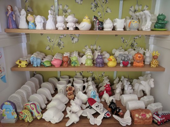 A shelf filled with lots of ceramic figurines and toys