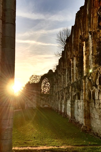 The sun is shining through the windows of a ruin