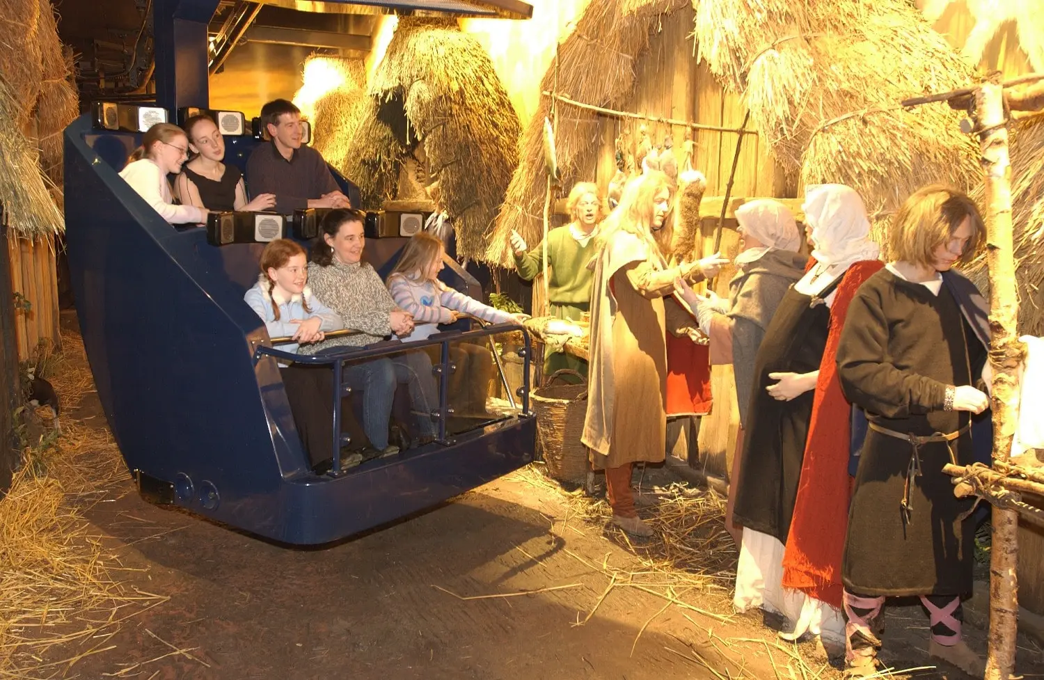 A group of people are riding a roller coaster in a dark room