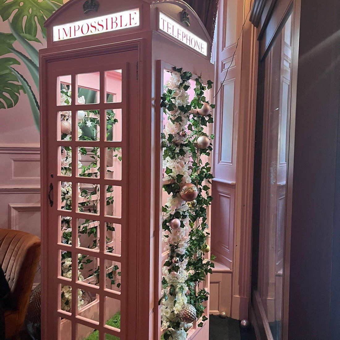 Pink telephone booth decorated with flowers; 