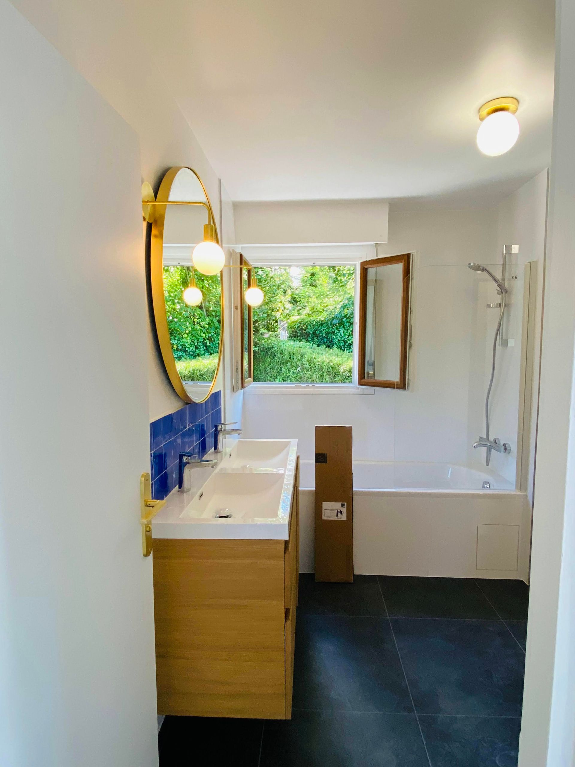 Une salle de bains avec un meuble sous vasque en bambou et une baignoire