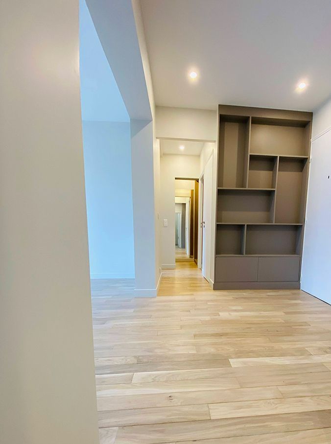 Un intérieur avec un couloir et une bibliothèque couleur taupe