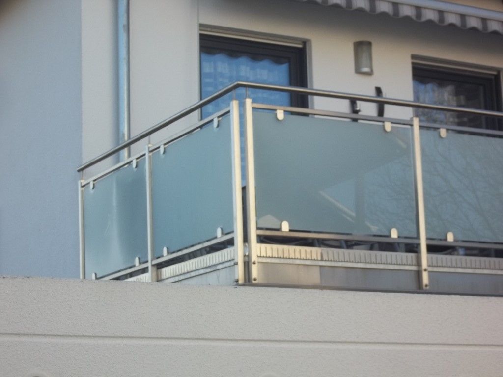 Balkongeländer mit Milchglasscheiben und Metallrahmen