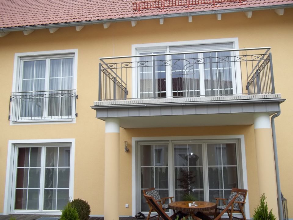 Dekoratives Metallgeländer an einem Balkon auf zwei Säulen