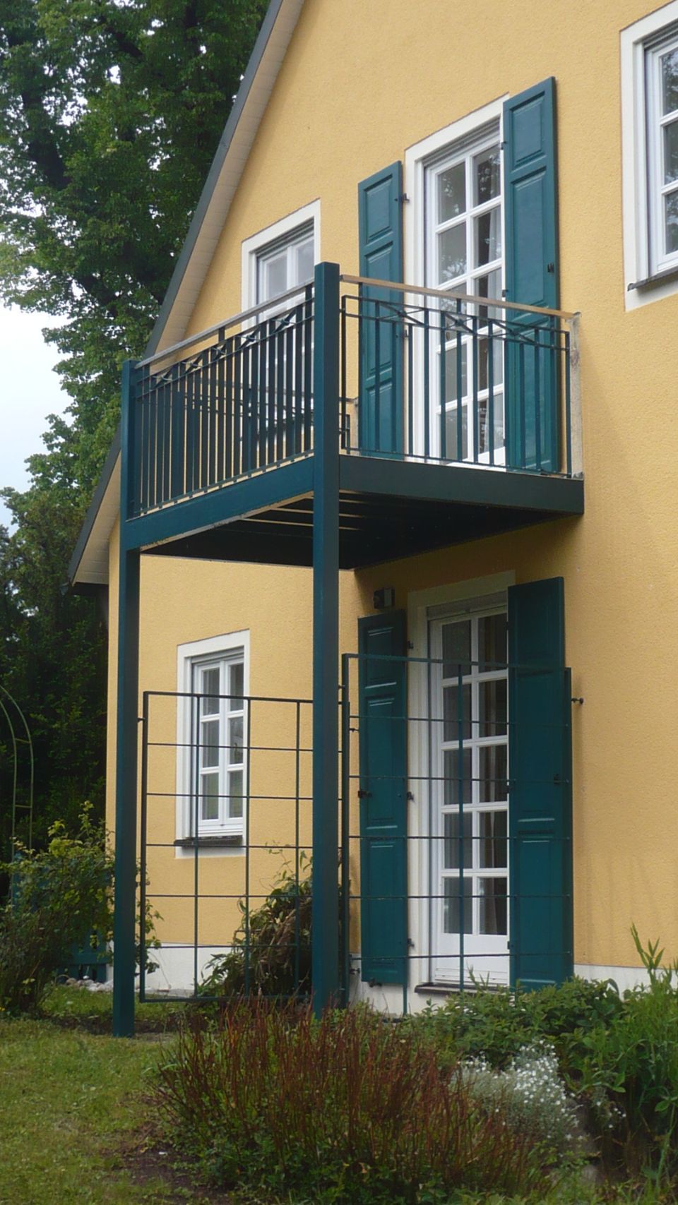 Balkon auf zwei Säulen mit Geländer aus schwarzem Metall