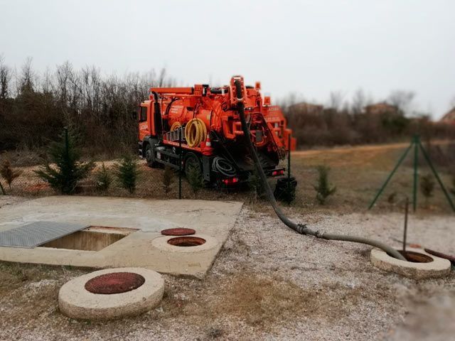 Un camión de vacío está bombeando agua a un tanque séptico.
