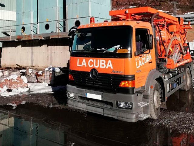 Un camión a la cuba está estacionado en un charco de agua