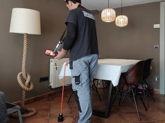 Un hombre con una camisa negra está de pie en un comedor.