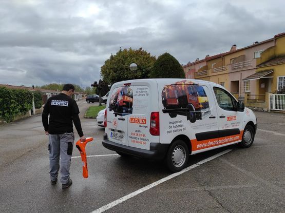 Un hombre está parado junto a una camioneta en un estacionamiento.