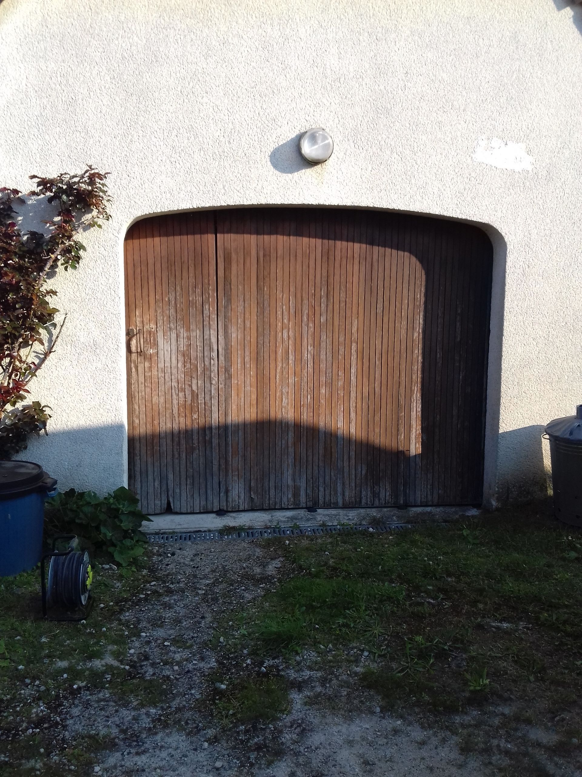 Une porte de garage avant remplacement et installation d'un système de motorisation. 