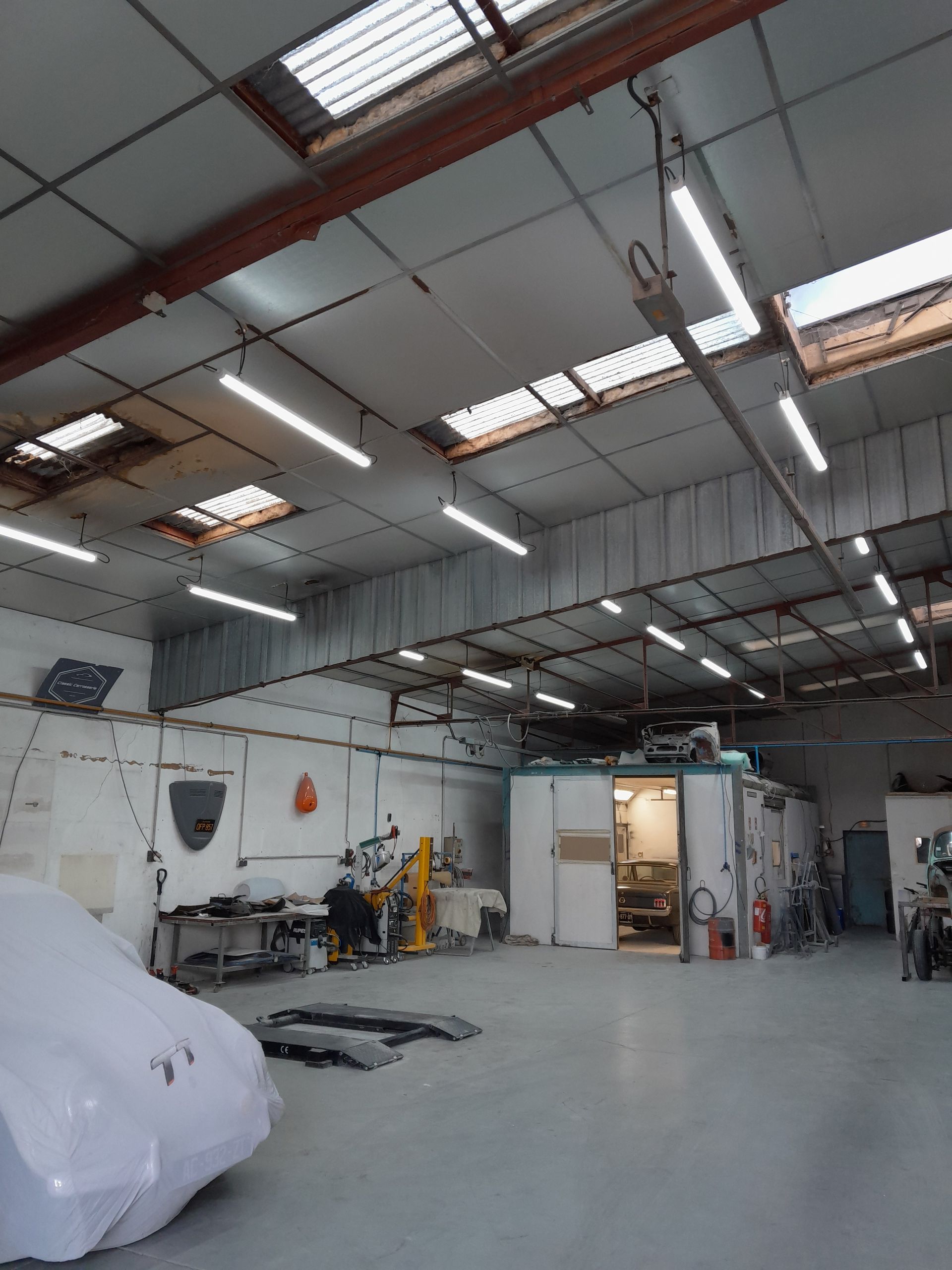 Intérieur d'un entrepôt industriel avec de hauts plafonds éclairés.