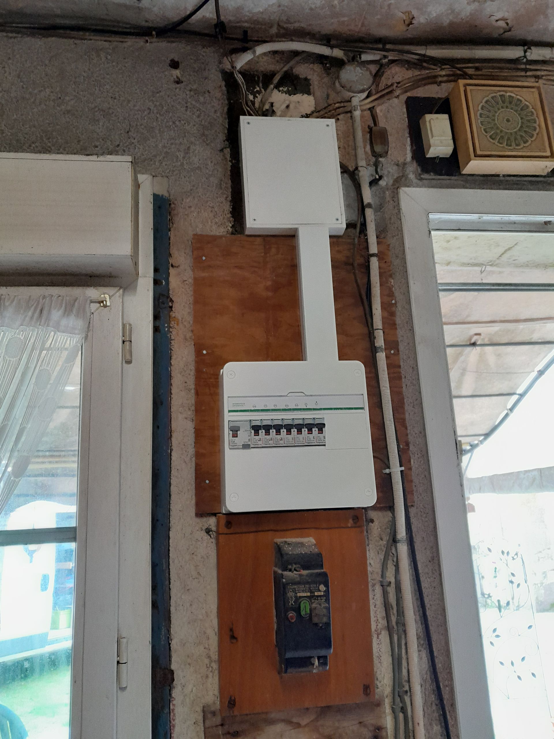 Compteur électrique fixé sur une planche de bois.