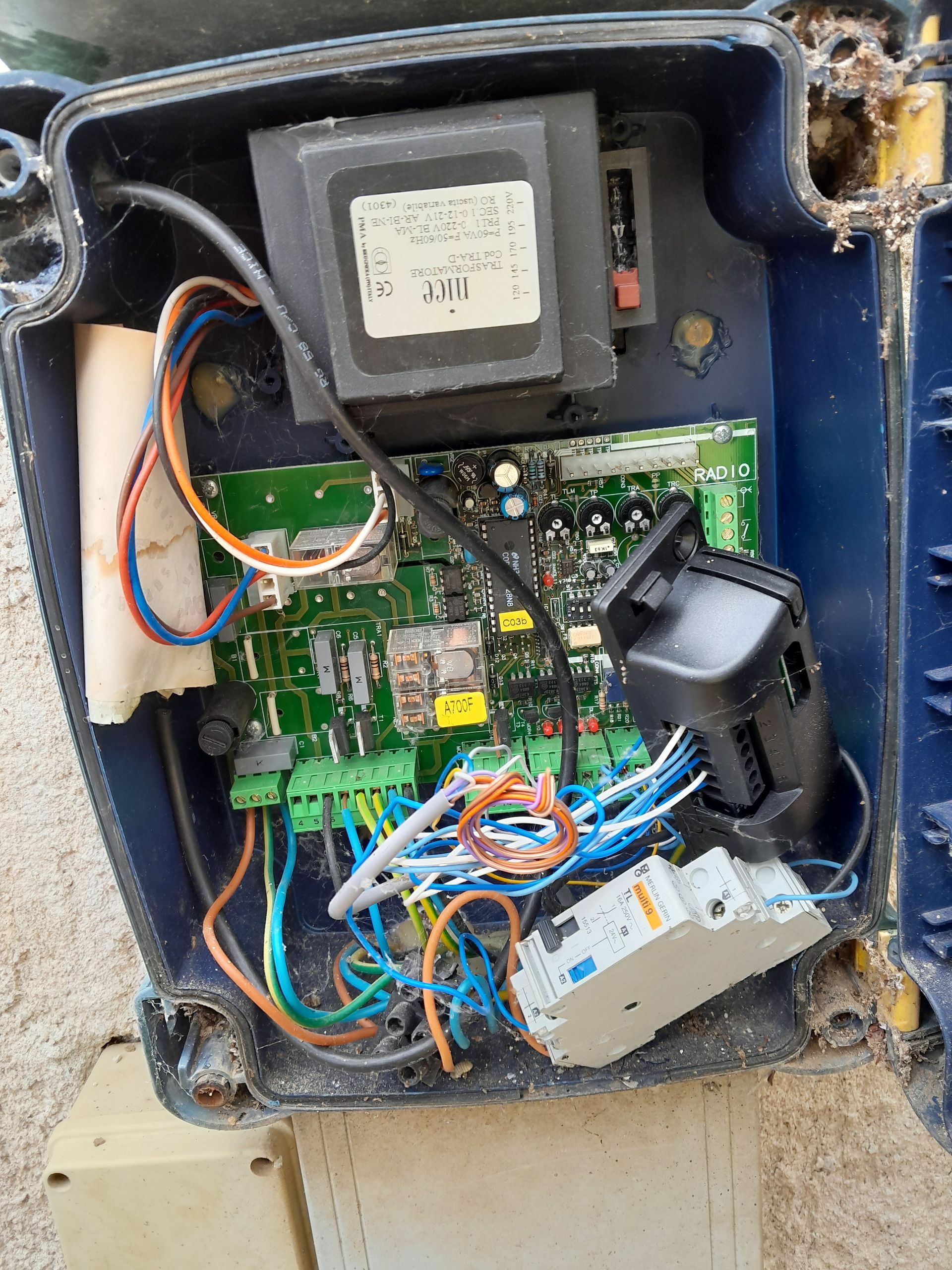 Boîtier de commande électrique ouvert avec circuit imprimé exposé, fils et composants.