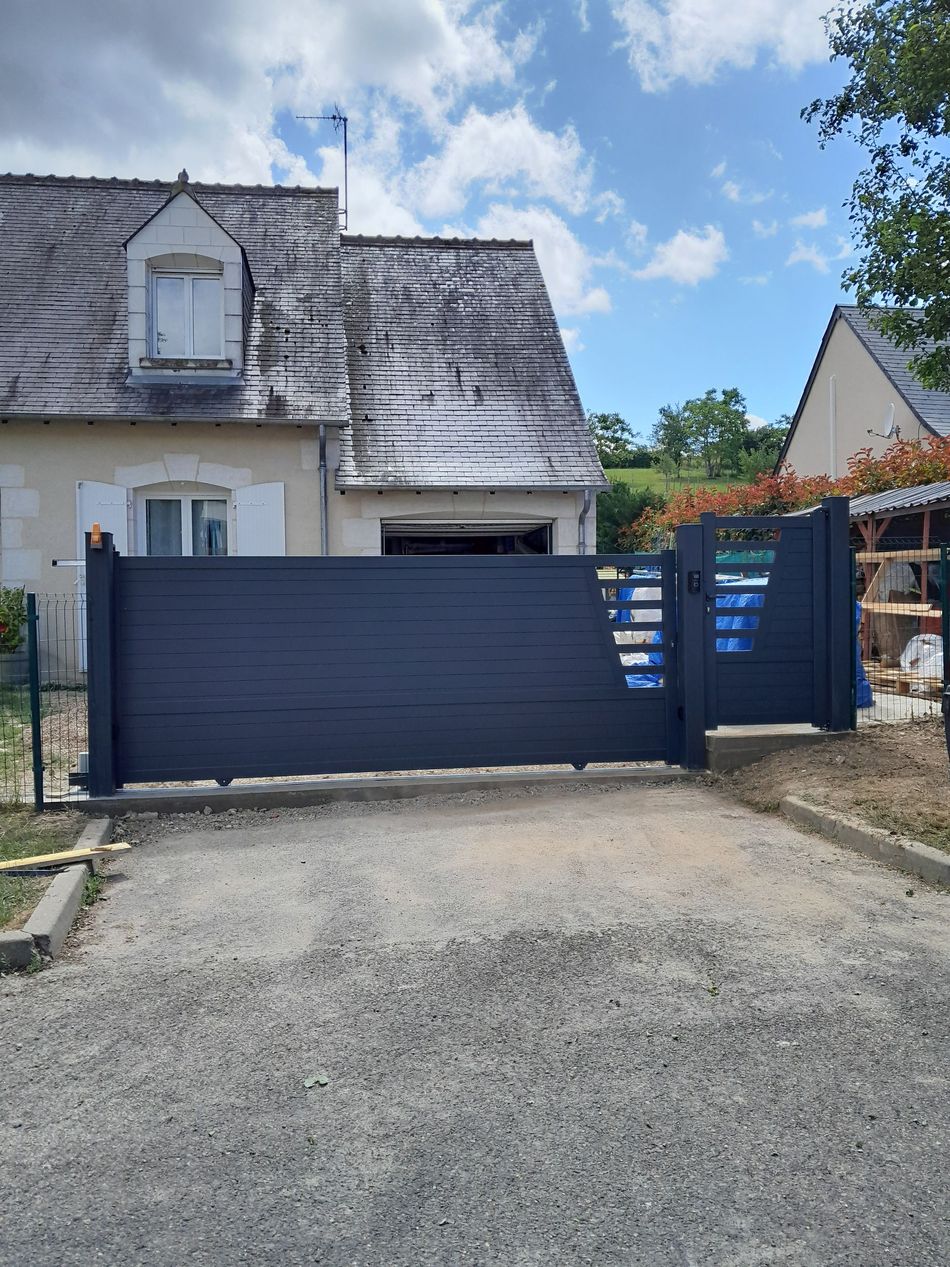 Un portail coulissant bleu avec un système de motorisation.