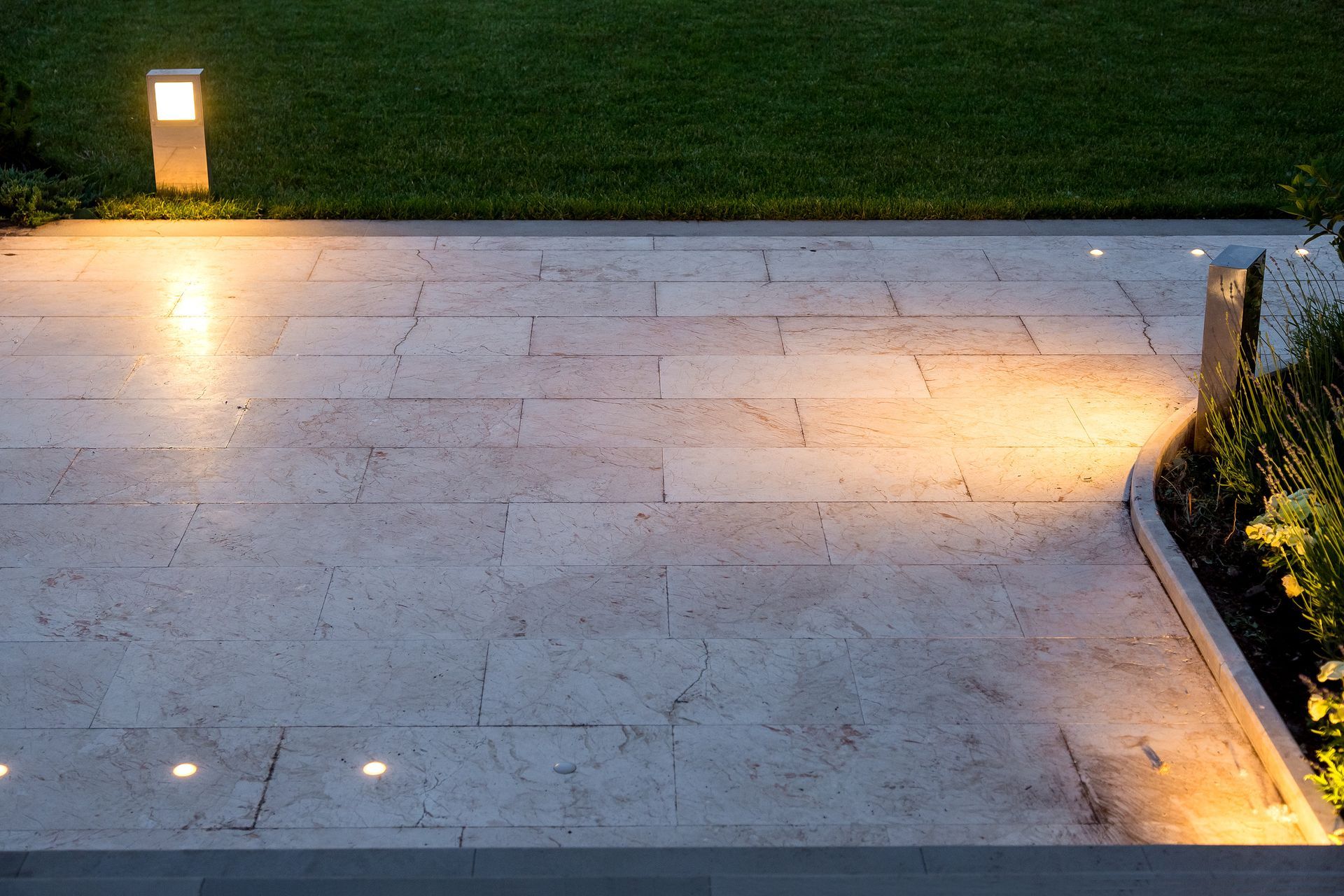 Terrasse en pierre illuminée la nuit.