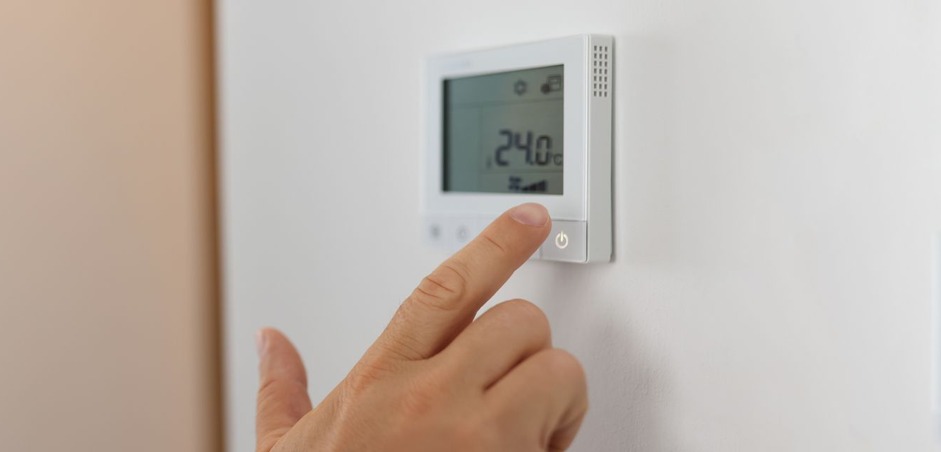 Un thermostat numérique mural.
