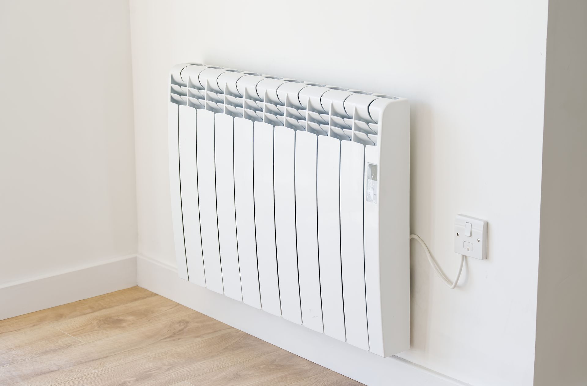 Radiateur électrique mural blanc sur un mur blanc.
