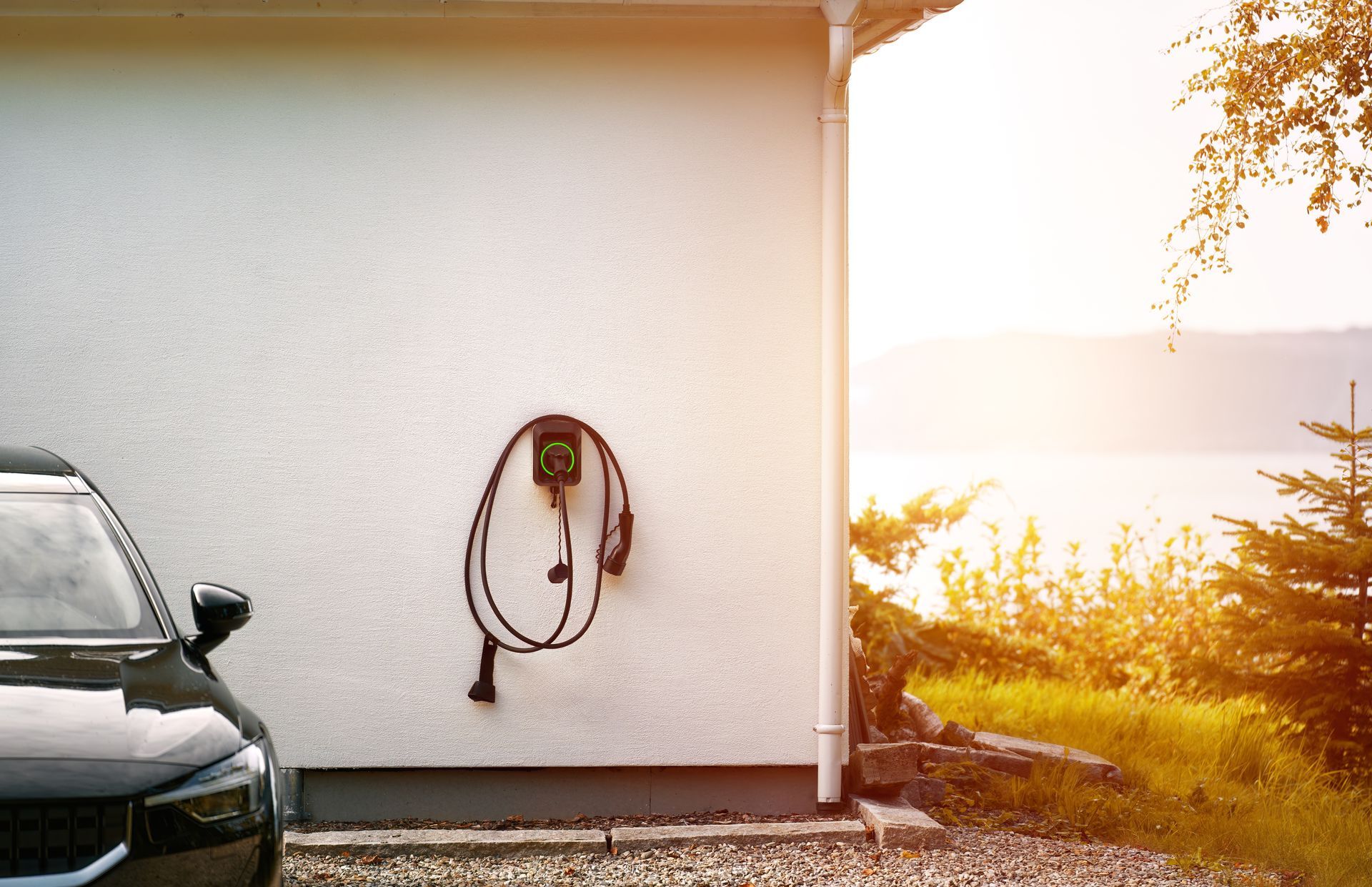Voiture noire garée près d'un mur avec une prise de recharge individuelle.