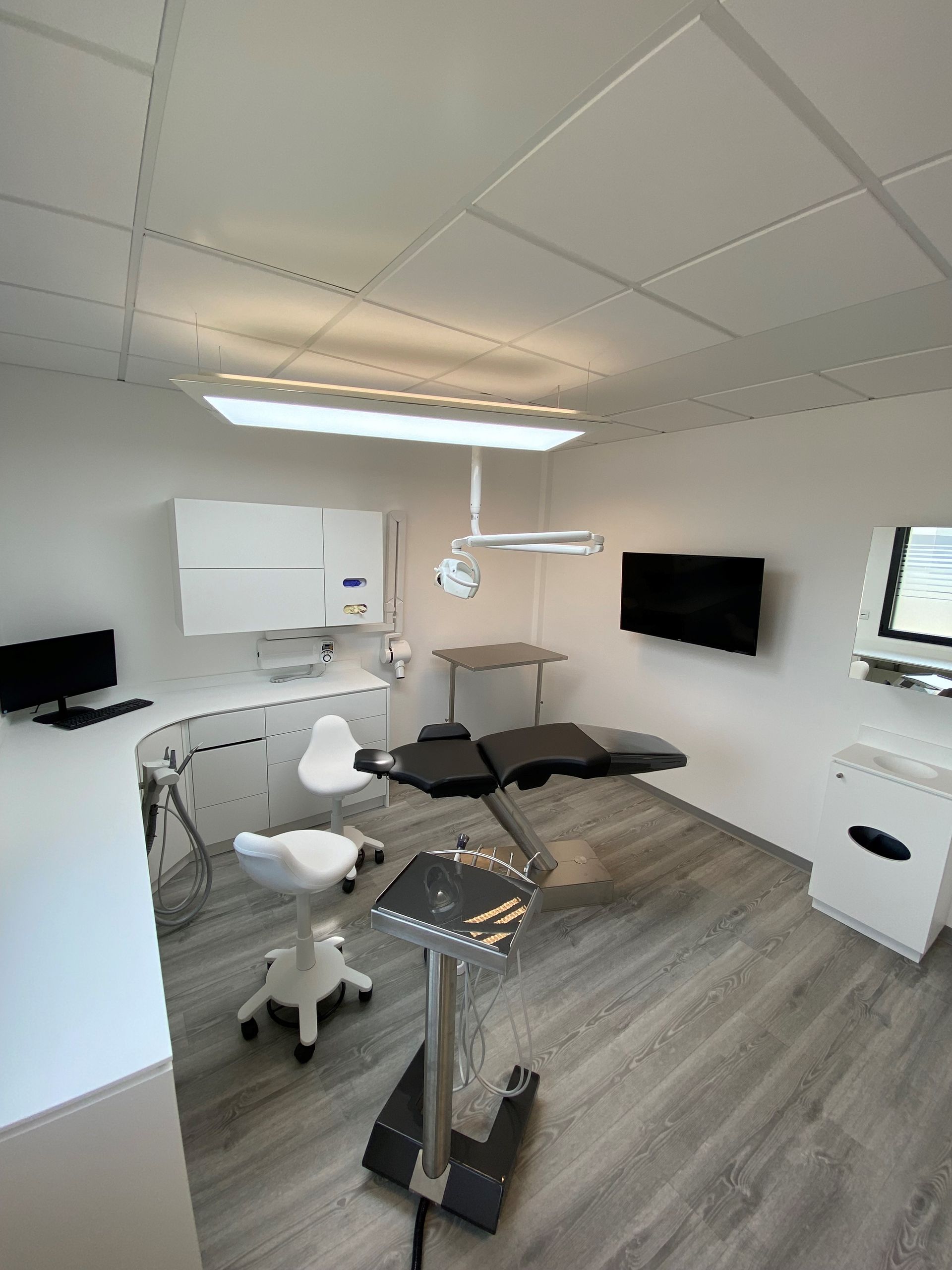 Vu d'ensemble d'un cabinet dentaire avec fauteuil noir