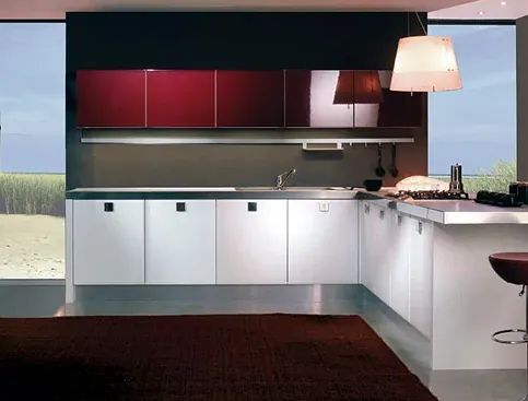 Una cocina con gabinetes rojos y gabinetes blancos.