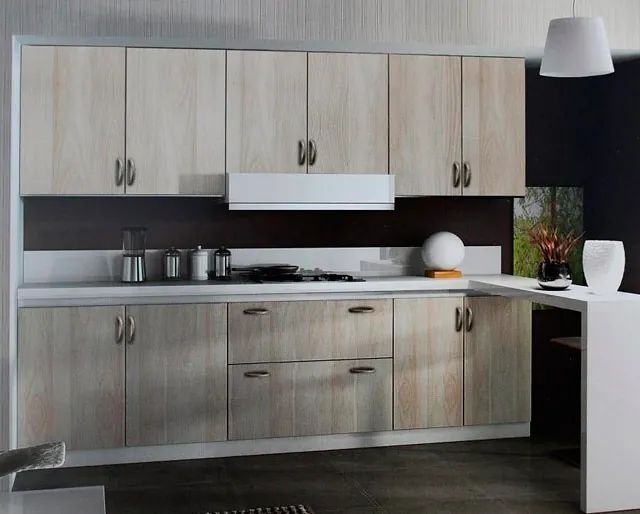 Una cocina con gabinetes de madera y encimeras blancas.