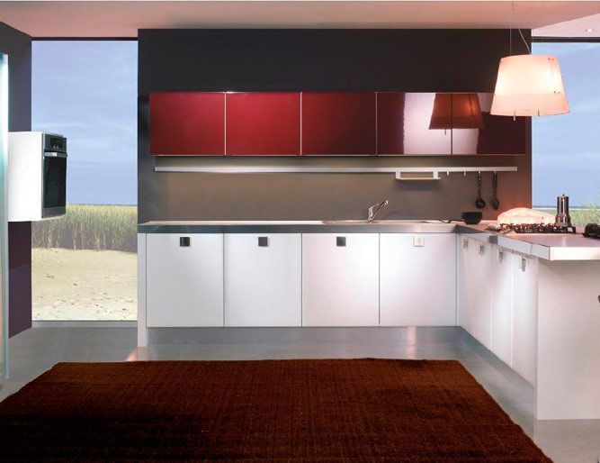 Una cocina con gabinetes rojos y gabinetes blancos.