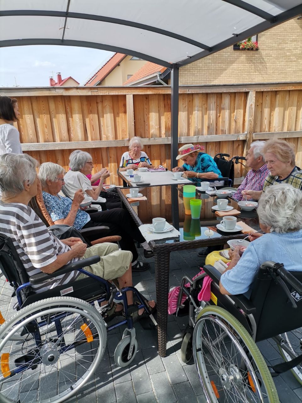 Bewohner der Senioren-Wohngruppe von Ambulanter Pflegedienst Floß beim Essen im Garten