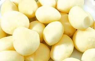 Patatas peladas, de color amarillo claro, bien apretadas unas contra otras.