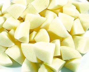 Papas crudas cortadas en cubitos, listas para cocinar, colores blanco y blanquecino, toma de primer plano.