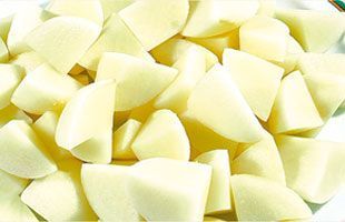 Patatas crudas picadas, de color amarillo pálido, listas para cocinar.