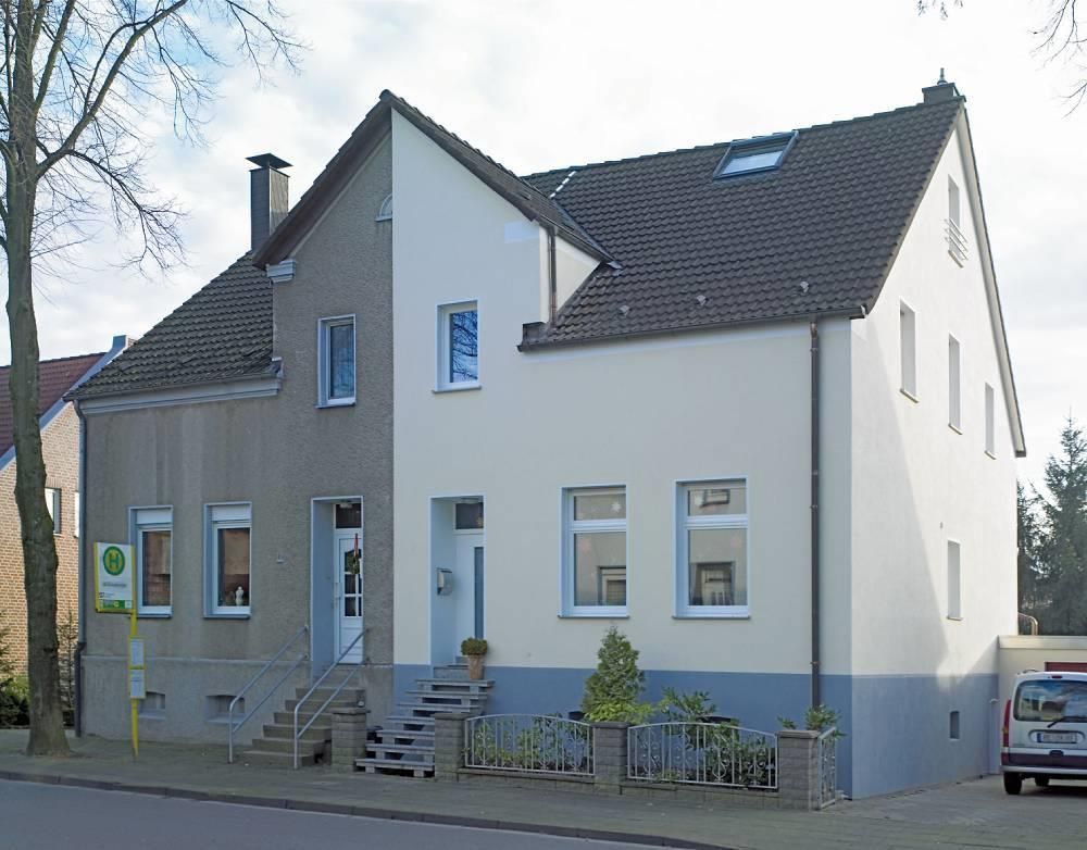 Ein weißer Lieferwagen steht vor einem weißen Haus