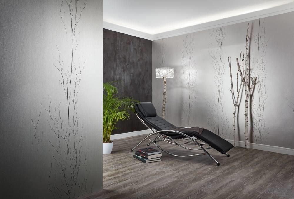 In einem Wohnzimmer steht ein Loungesessel neben einer Lampe.