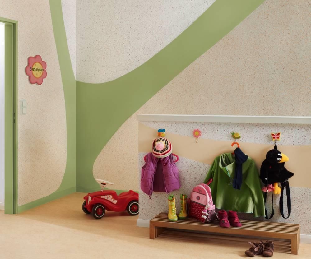 Ein Flur mit an Haken hängender Kleidung und einem roten Spielzeugauto