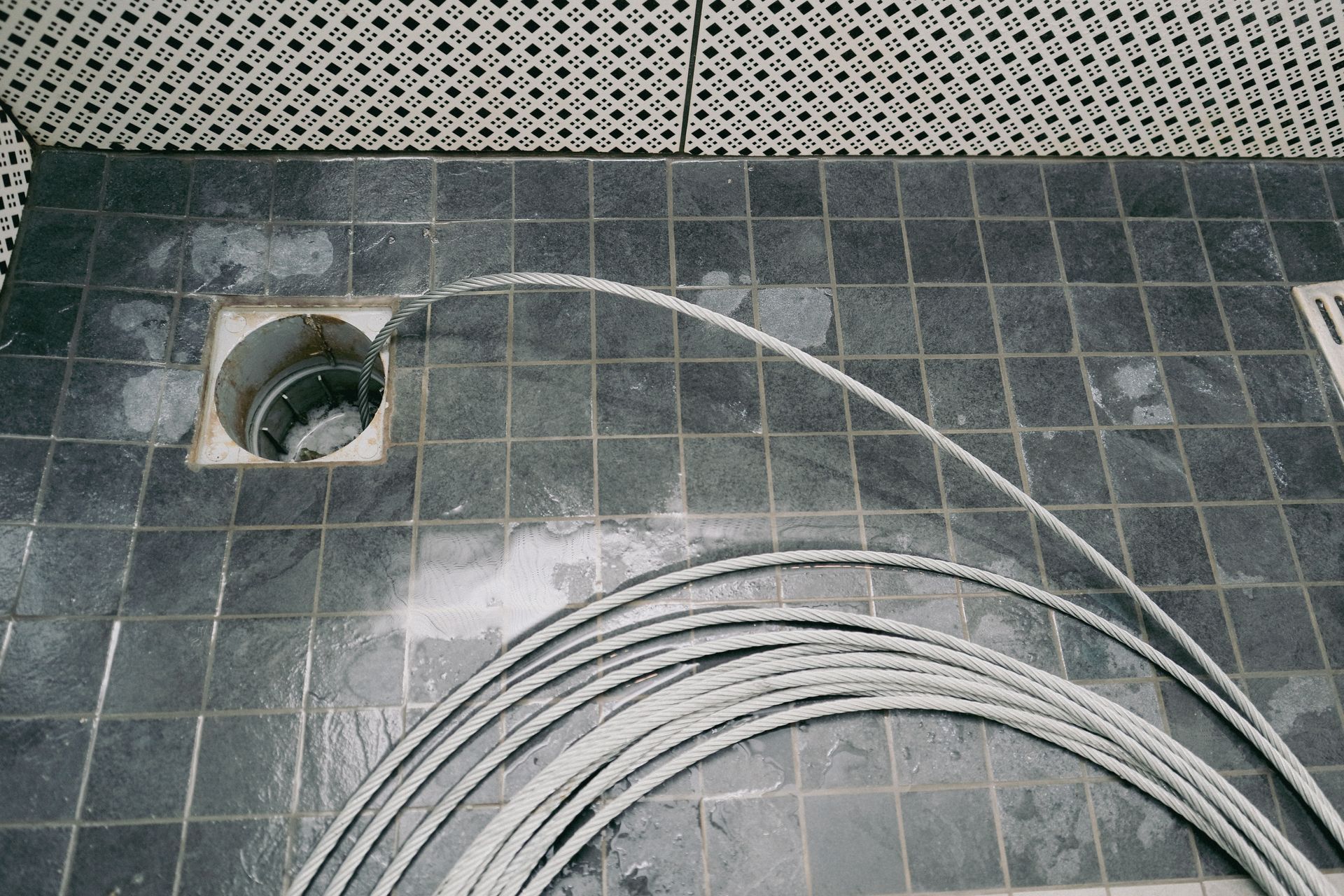 Débouchage d'une évacuation de douche italienne au furet.