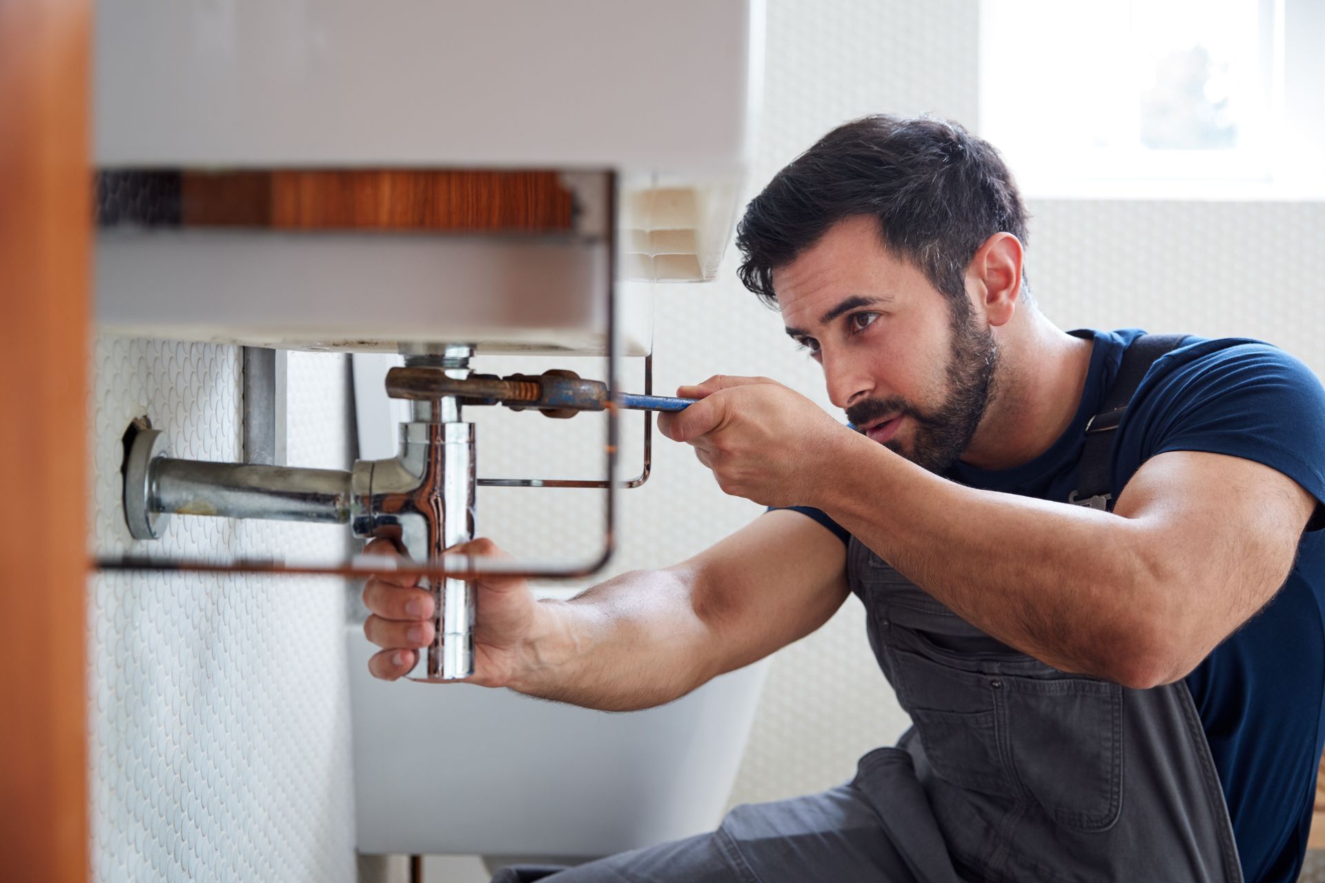 Plombier vissant une canalisation